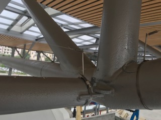 Fils tendus anti-pigeons sur charpente hall de gare